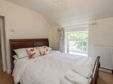 A bedroom with a bed and window at Plas Mawr in Groeslon