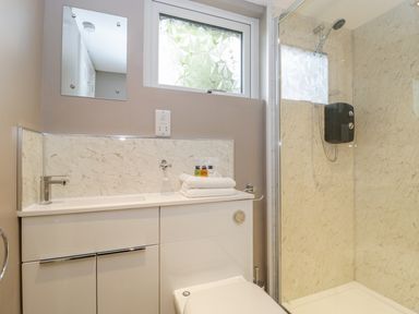 A bathroom with a sink cabinet toilet and a shower cubicle at Pheasant Lodge in Wimborne Minster
