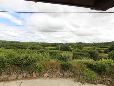 A rural landscape with green fields trees and a stone wall at Sunnywell Lanivet near Bodmin