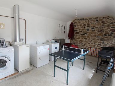 A utility room with a washing machine dryer and table tennis table at Sunnywell Lanivet near Bodmin