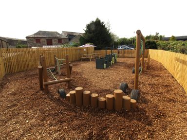 An outdoor play area with swings and climbing equipment at Cedar Lodge, Lanivet near Bodmin
