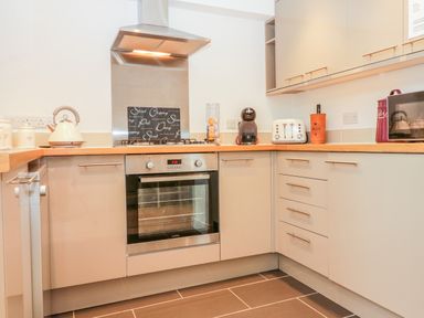 A kitchen with an oven a toaster a kettle and cabinets at Sunvale in Teignmouth