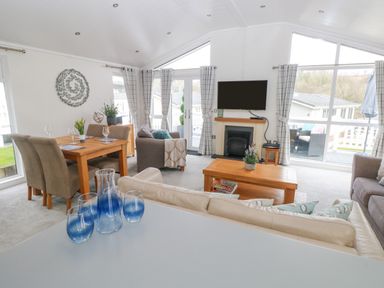 A living room with sofas coffee table television and dining table at The Lookout in Stepaside