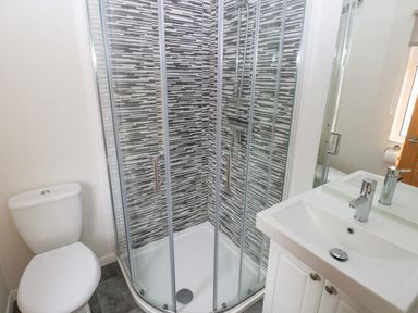 A bathroom with a corner shower with sliding glass doors a toilet and a sink with a mirror at The Lookout in Stepaside