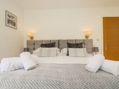 A bedroom with a double bed with pillows and rolled towels on it at Birch in Truro