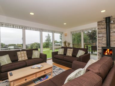 A living room with brown sofas a wooden coffee table and a fireplace at Hazel in Truro