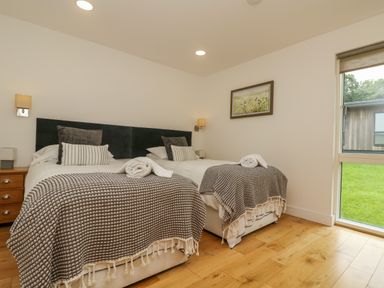 A bedroom with two single beds side by side with blankets and pillows a window and a painting on the wall at Hazel in Truro