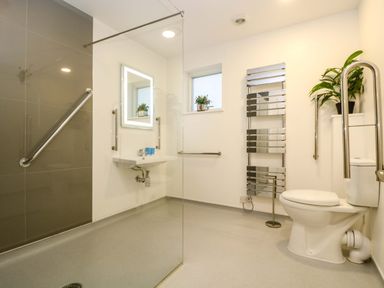 A bathroom with a toilet sink mirror heated towel rail and plants at Oak in Truro