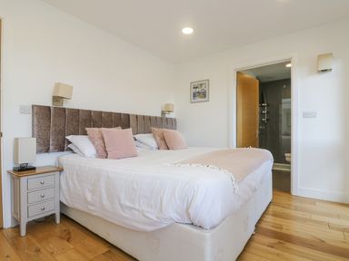 A bedroom with a large bed and side table with lamp at Rowan in Truro