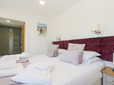 A bedroom with a double bed with pillows and towels and robes on the bed at Willow in Truro