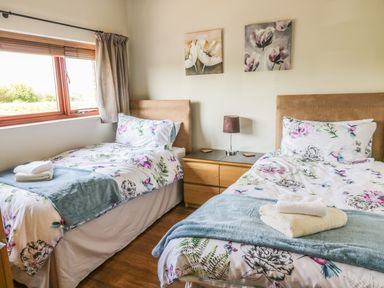 A bedroom with two single beds bedside table and lamp at Boavista in Carnforth
