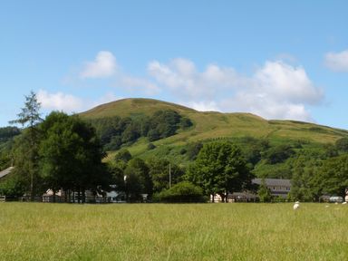 A green hill with scattered trees and houses at Boavista in Carnforth