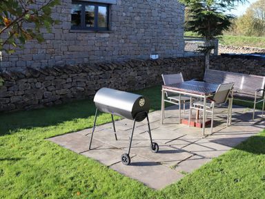 A garden with a grill and seating at Boavista in Carnforth