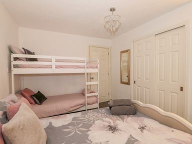 A bedroom with a bunk bed and a double bed with folded towels on it at Sunset Lodge in Tattershall