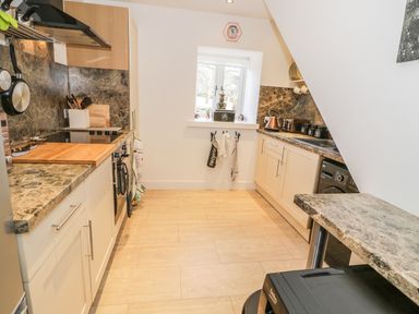 A kitchen with countertops cabinets a window oven stovetop and sink at Skovhaven in Catton