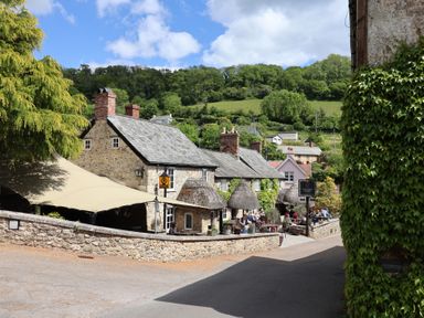 A cafe with outdoor seating and a stone wall at Pottery Barn Branscombe