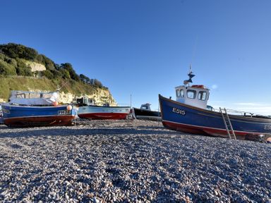 Three boats on a pebbly beach at Pottery Barn in Branscombe