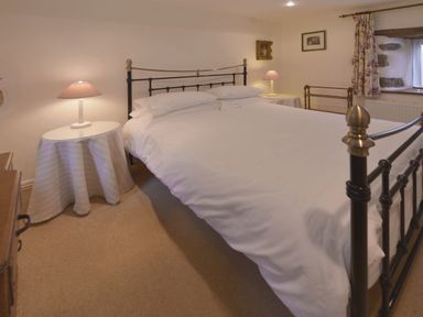 A bedroom with a double bed and two bedside tables with lamps at Water Barn in Manaton near Lustleigh