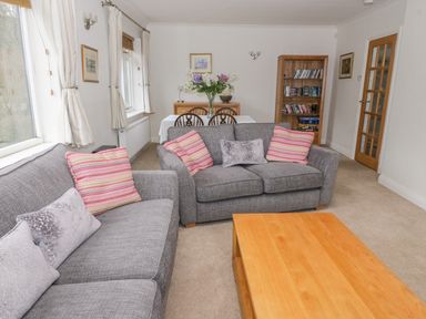 A living room with two gray sofas and a wooden coffee table at The Dene in Betws-y-Coed
