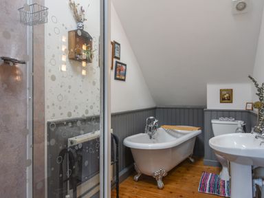 A bathroom with a clawfoot bathtub sink toilet and shower at The Linhay in Lydford