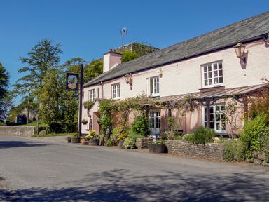 A street view of a pink building with plants and flowers along the wall at Townend Barn in Lydford