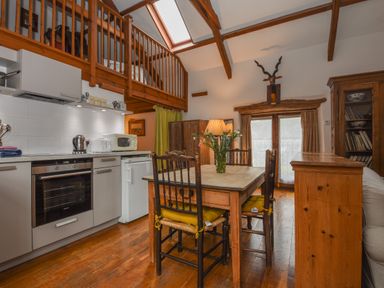 A kitchen and dining area with wooden furniture and exposed beams at Townend Barn in Lydford