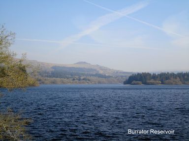 A large water reservoir with trees and hills in the background at Burham Barn in Dousland near Yelverton