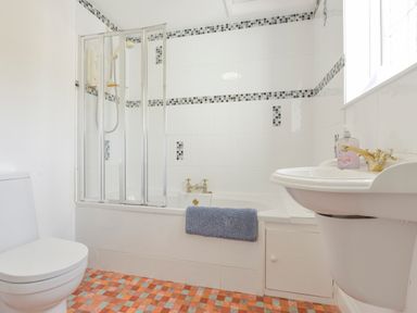 A bathroom with a toilet sink bathtub and tiled floor at Little Gate Cottage in North Bovey