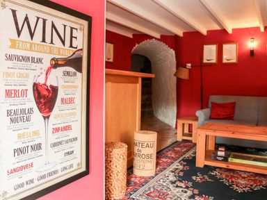 A living room with a wine poster on the wall a gray couch a wooden coffee table and patterned rug at Sandridge Barton in Stoke Gabriel