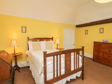 A bedroom with a wooden bed and two lamps on side tables at Wootton House in Butleigh Wootton near Compton Dundon