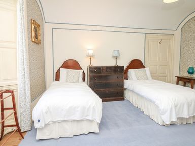 A bedroom with two single beds a wooden chest of drawers and two lamps at Wootton House in Butleigh Wootton near Compton Dundon