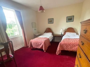 A bedroom with two single beds and a table at Wootton House Butleigh Wootton near Compton Dundon