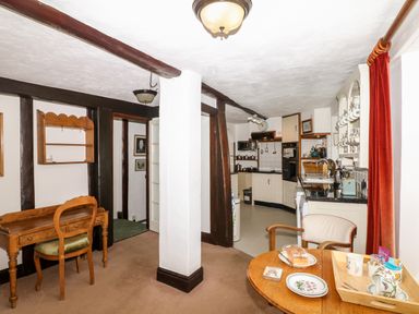 A kitchen and dining area with wooden furniture and exposed beams at Castle View in Dunster