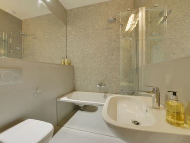A bathroom with a bathtub shower sink toilet and soap dispenser at Gardeners Cottage in Talaton near Ottery St Mary