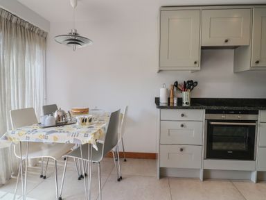 A kitchen with a table set for tea at The Old Log Shed in Honiton