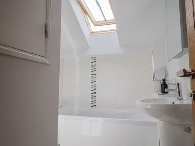 A bathroom with a bathtub and sink at The Old Log Shed in Honiton