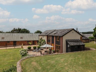A house with patio and garden area at The Old Log Shed in Honiton