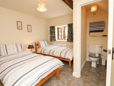 A bedroom with two beds and an ensuite bathroom at Battens in Colyton