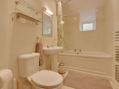 A bathroom with a toilet sink bathtub mirror and towel at Lew Quarry Cottage in Lewdown