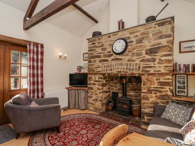 A living room with a fireplace and television at Miners Dry in Gulworthy, near Tavistock