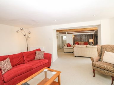 A sitting room with sofas a glass coffee table and a floor lamp at West Henstill House in Sandford Devon