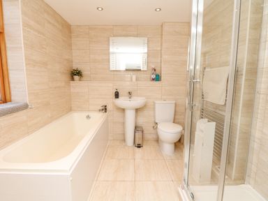 A bathroom with a bathtub sink toilet shower and mirror at West Henstill House in Sandford Devon