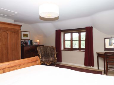 A bedroom with a bed and wardrobe at Hope Cottage in Riddlecombe near Winkleigh