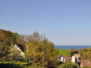 A coastal village with houses trees and the sea in the background at Bramble Cottage in Ringmore