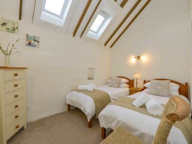 A bedroom with two single beds and skylight windows at Bramble Cottage in Ringmore