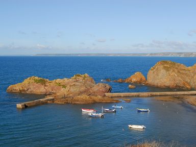 A small harbor with boats and rock formations at 4 Coastguards Cottage in Hope Cove