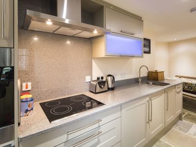 A kitchen with an electric stovetop toaster kettle and sink at Mill Barn in Woolston near Salcombe