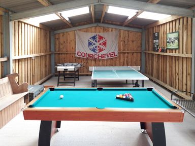 A game room with a pool table ping pong table foosball table and wooden bench at Mill Barn in Woolston near Salcombe