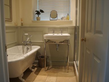 A bathroom with a bathtub and sink at Coach House Cottage Strete, near Dartmouth