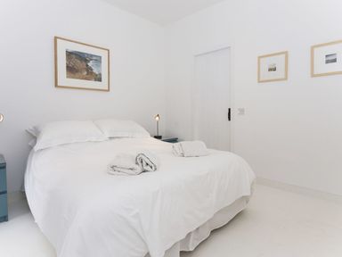 A bedroom with a bed covered in white bedding and towels on top at The Gallery in Aveton Gifford